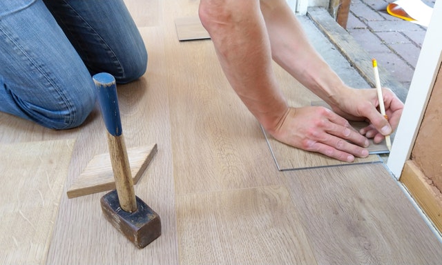 a man measuring the edge of the floor